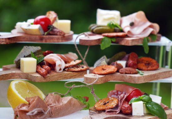Platte mit Wurst, Käse, grünen Oliven Platte mit Wurst, Käse, grünen Oliven, getrockneten Früchten und frischen Kräutern.