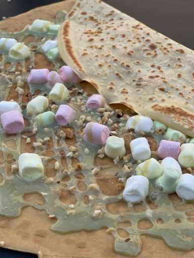 Ein Crêpe mit Marmelade und bunten Mini-Marshmallows.
